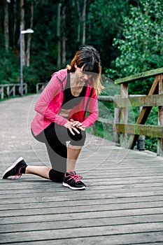 Athlete woman crouched with knee injury