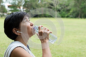 Athlete woman drinking water after exercise