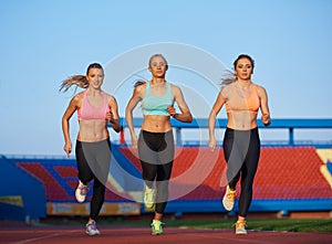 Athlete woman group running on athletics race track