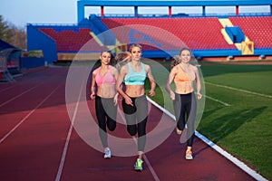 Athlete woman group running on athletics race track