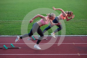 Athlete woman group running on athletics race track