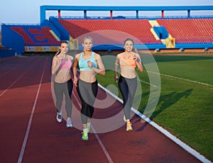 Athlete woman group running on athletics race track