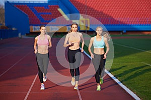 Athlete woman group running on athletics race track