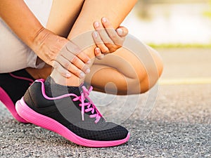 Athlete woman has ankle injury, sprained leg during running training. sport concept.