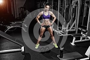 athlete woman posing with a dumbbell in the gym