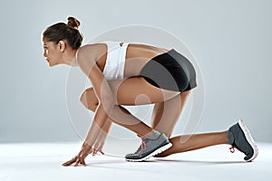 Athlete, woman and ready to race in studio as runner for fitness, training and exercise for sports. Healthy, female