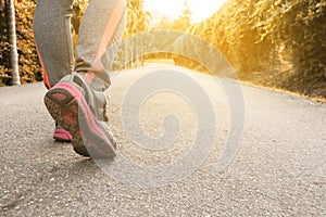 Athlete woman`s feet with running shoe walking in public park.female active lifestyle for future competition concept