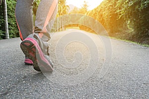 Athlete woman`s feet with running shoe walking in public park.female active lifestyle for future competition concept