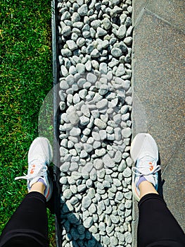 Athlete woman in sneakers on walking path