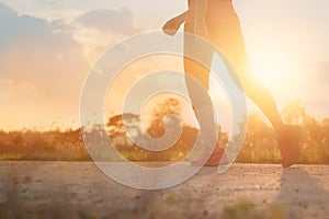 Athlete woman walking exercise on rural road in sunset background, healthy and lifestyle concept