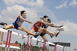 Athletes Clearing Hurdles In Race photo