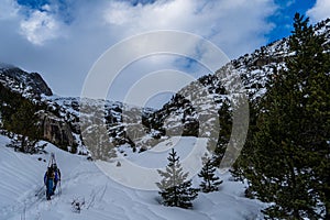 Athletes doing backcountry ski with a landscape of snowy mountains on a sunny day.