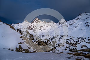 Athletes doing backcountry ski with a landscape of snowy mountains on a sunny day.