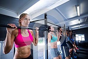 Athletes doing chin-ups in gym