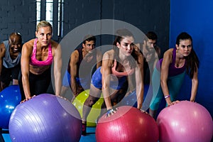 Athletes exercising with fitness ball in gym