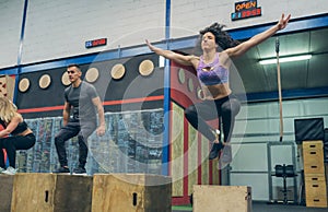Athletes exercising jumping wooden box