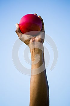 Athletes hand holding shot put ball