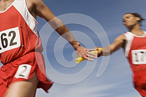 Athletes Passing Baton In Relay Race photo