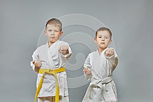 Athletes perform a punch on a gray background