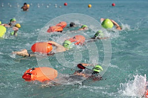 Athletes swimming free style in the sea during triathlon competition. Swimmer in the ocean
