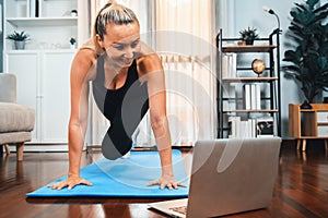 Athletic and active senior woman doing online plank climbing at home. Clout