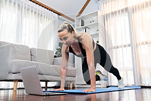 Athletic and active senior woman doing online plank climbing at home. Clout