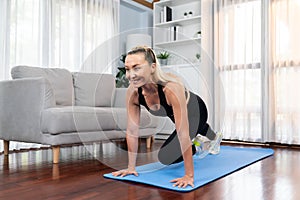 Athletic and active senior woman doing plank climbing at home. Clout