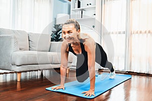 Athletic and active senior woman doing plank climbing at home. Clout