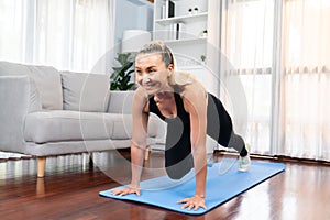 Athletic and active senior woman doing plank climbing at home. Clout