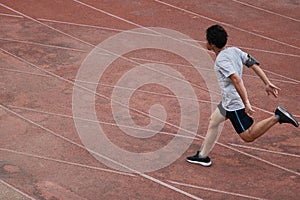 Athletic Asian runner sprinter crossing the finish line.