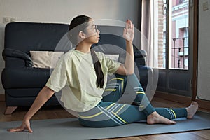 Athletic asian woman in sportswear doing fitness stretching exercises at home.