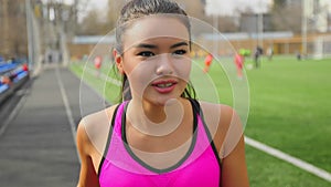 Athletic asian young girl is running on stadium. Fitness, sports concept.