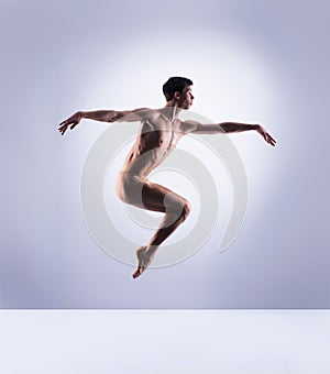 Athletic ballet dancer in a perfect shape performing