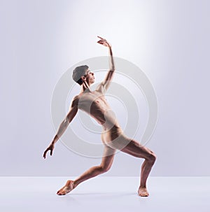 Athletic ballet dancer in a perfect shape performing