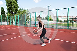 Athletic basketball player dribbles the ball on the basketball field