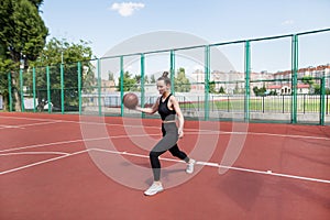 Athletic basketball player dribbles the ball on the basketball field