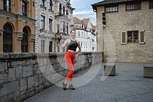 Athletic beautiful woman during fitness class in old european city