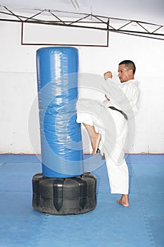 Athletic black belt karate giving a forceful knee kick during a