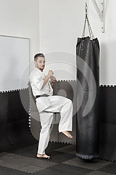 Athletic black belt karate giving a forceful knee kick