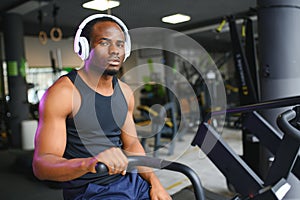 Athletic black man doing cardio workout on exercise bike in gym. Concept of sport and healthy lifestyle