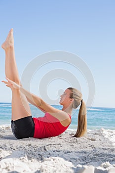 Athletic blonde doing pilates core exercise