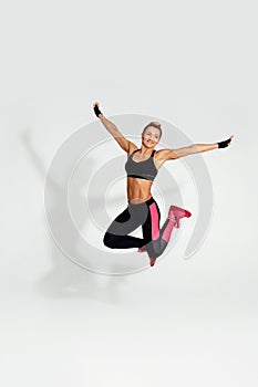 athletic blonde woman in black sportswear jumping