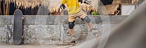 Athletic boy in helmet and knee pads learns to skateboard with in a skate park. Children education, sports BANNER, LONG