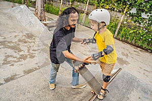 Athletic boy learns to skateboard with a trainer in a skate park. Children education, sports