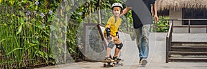 Athletic boy learns to skateboard with a trainer in a skate park. Children education, sports BANNER, LONG FORMAT