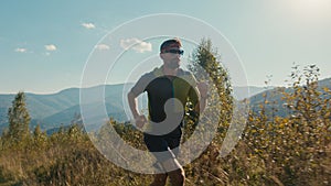 Athletic Caucasian man male guy sportswear sunglasses runner hiker running valley hiking run moving climbing up mountain