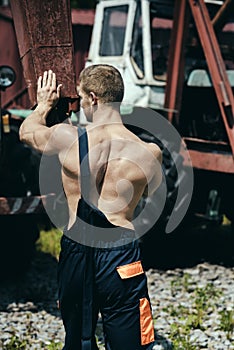 Athletic concept. Athletic man push heavy machinery. Worker with athletic torso. Athletic activity