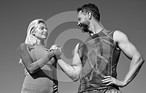 athletic couple arm wrestling in fitness wear outdoor, team
