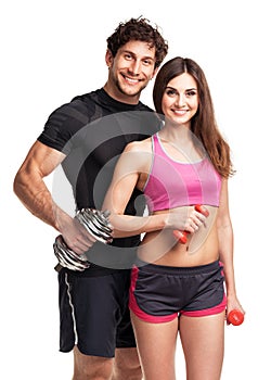 Athletic couple - man and woman with dumbbells on the white