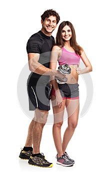 Athletic couple - man and woman with dumbbells on the white